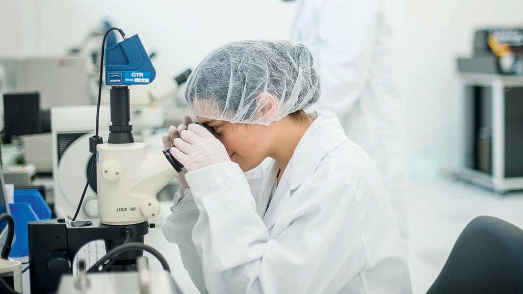 Forscher:innen arbeiten Microskop im Reinraum