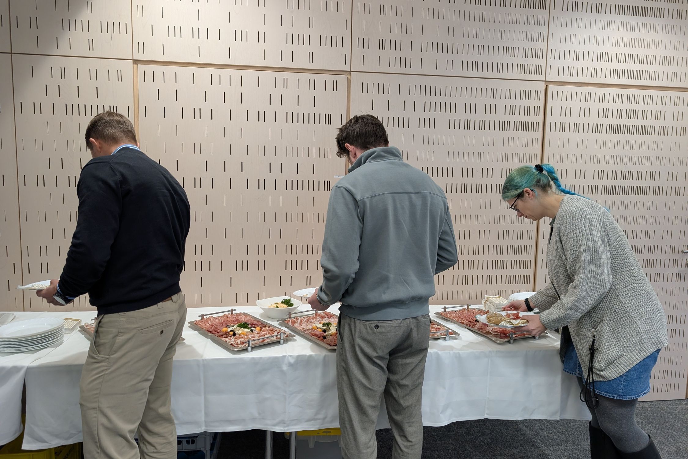 Teilnehmer:innen des Business Breakfast stellen sich am Frühstücksbuffet an