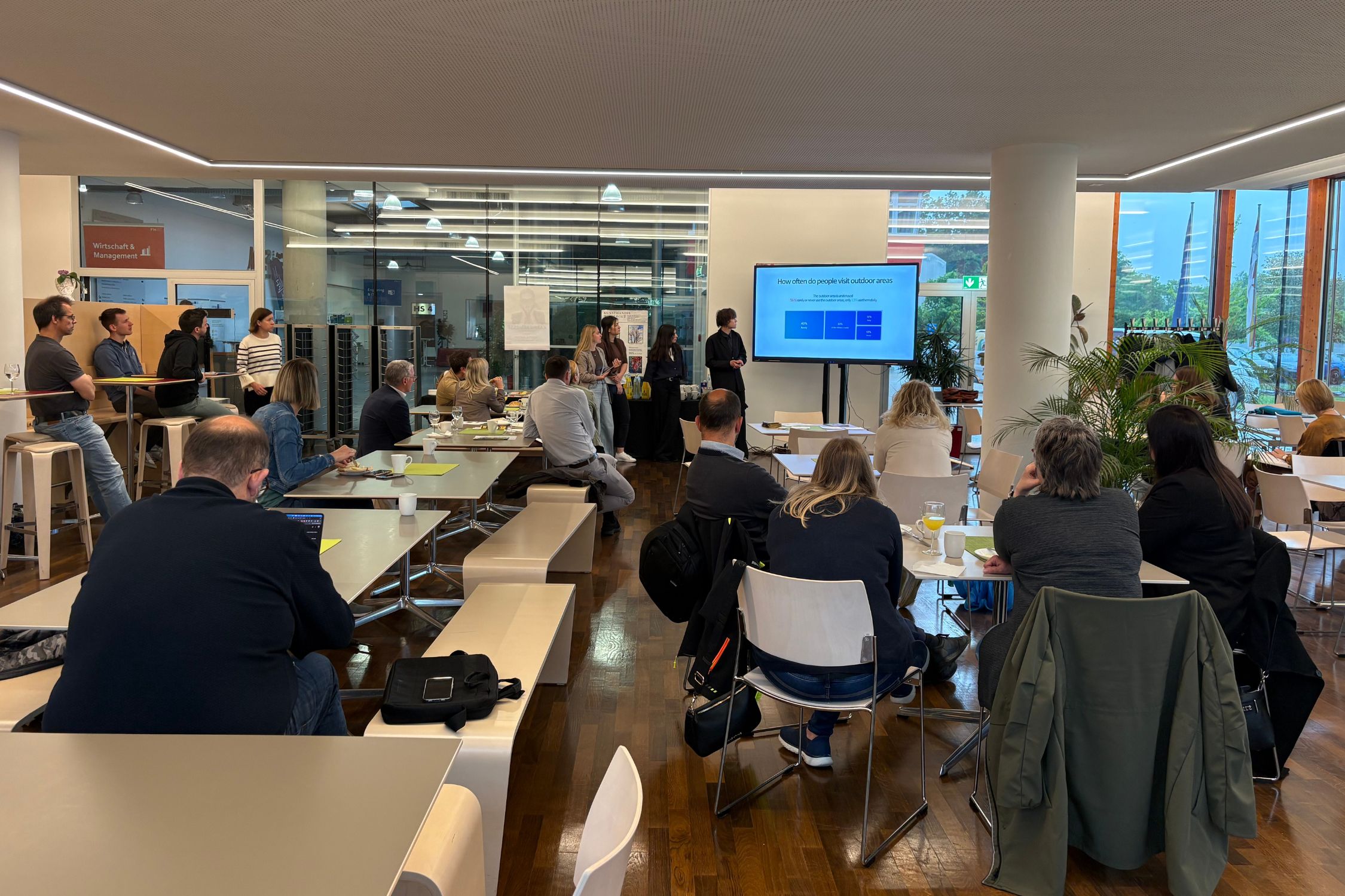 Im Zuge des Business Breakfasts wurden die Zwischenergebnisse der Umfrage zur Standortentwicklung präsentiert Studierende präsentieren eine Umfrage beim Business Breakfast